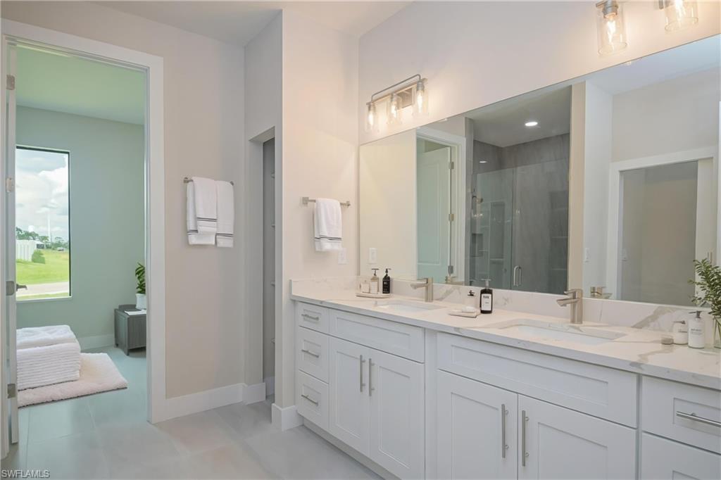 Bathroom featuring a shower stall and double vanity