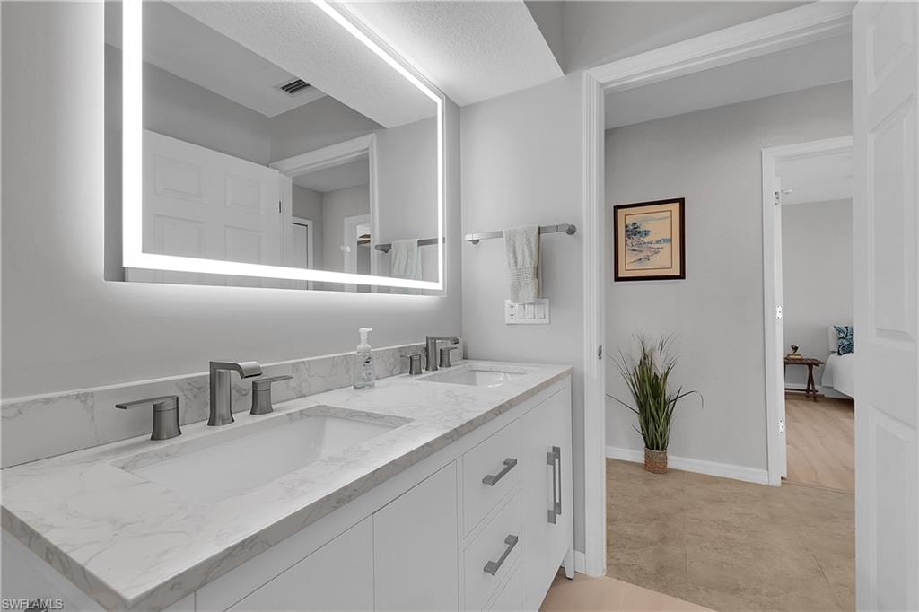 Bathroom with double vanity and baseboards
