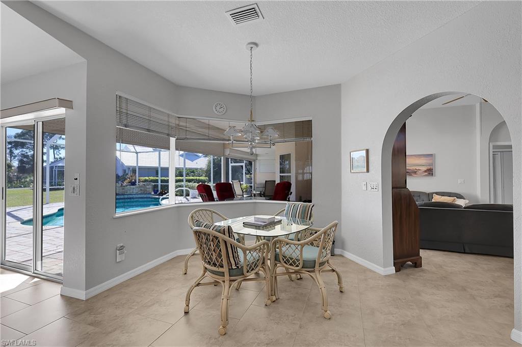 Dining area with bay window, fabulous view of the morning golfers,  suspended lighting, and textured ceilings and walls throughout