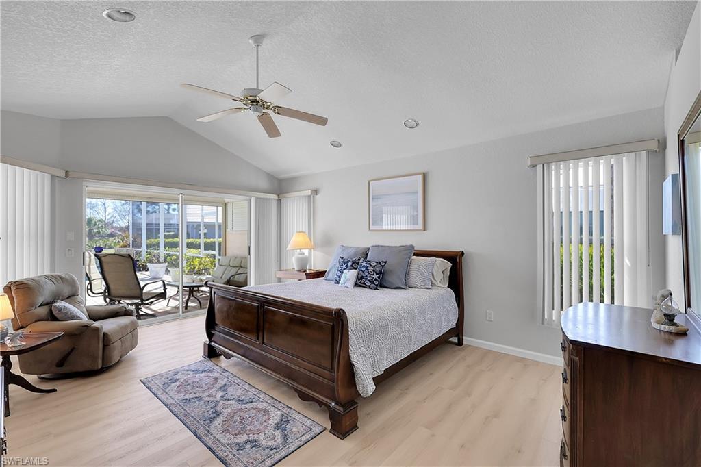 Bedroom with access to outside, new light wood-look LVP flooring, multiple windows, and ceiling fan