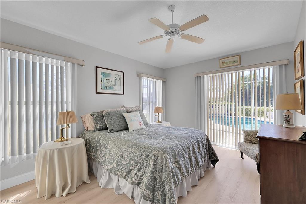 4th Bedroom featuring light wood-style floors, access to outside, walk in closet and a ceiling fan