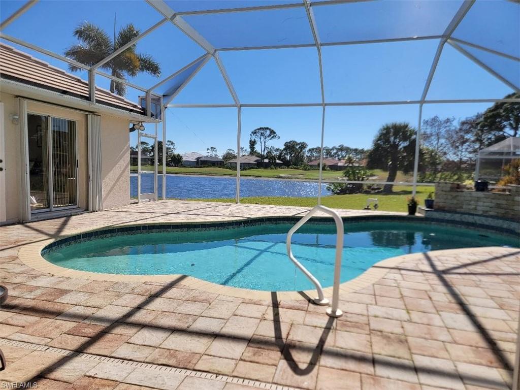 Outdoor pool with a waterfall, pavered patio, water and golf course view. You have a front row seat to the putting adventures!