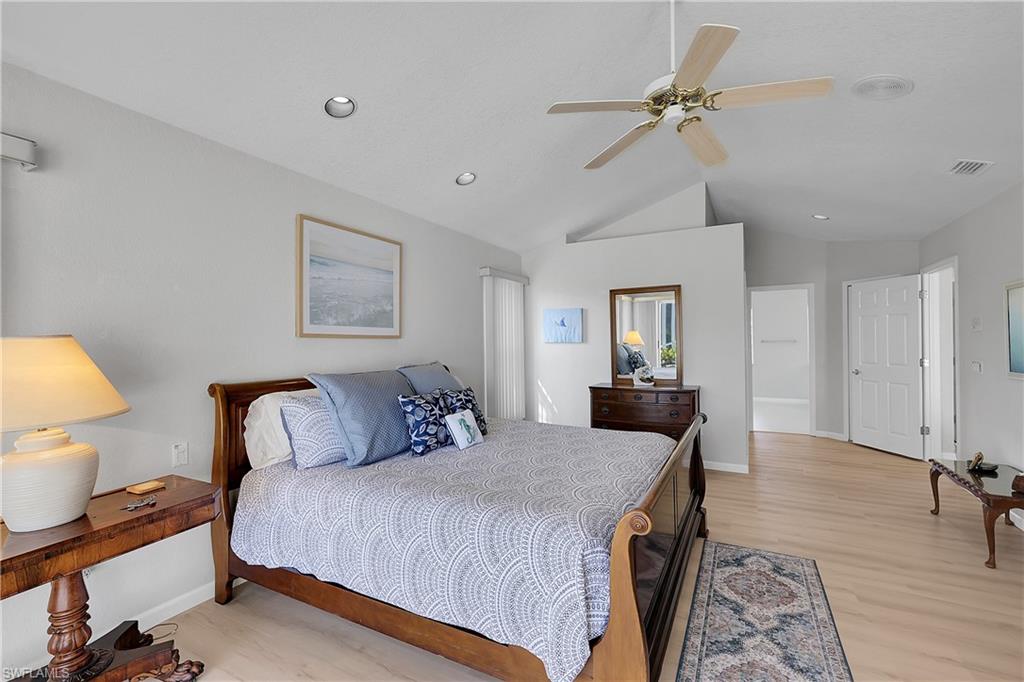 Bedroom with light wood finished floors, ceiling fan, recessed lighting, and vaulted ceiling