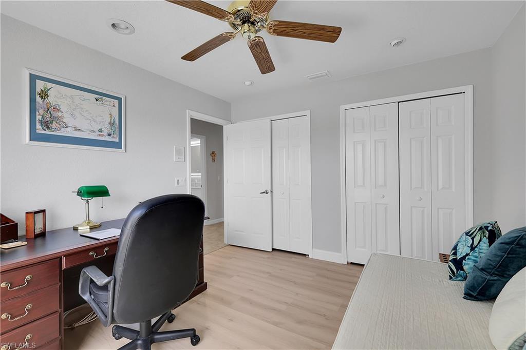 3rd Bedroom featuring two closets, light wood-style flooring, a desk, and ceiling fan