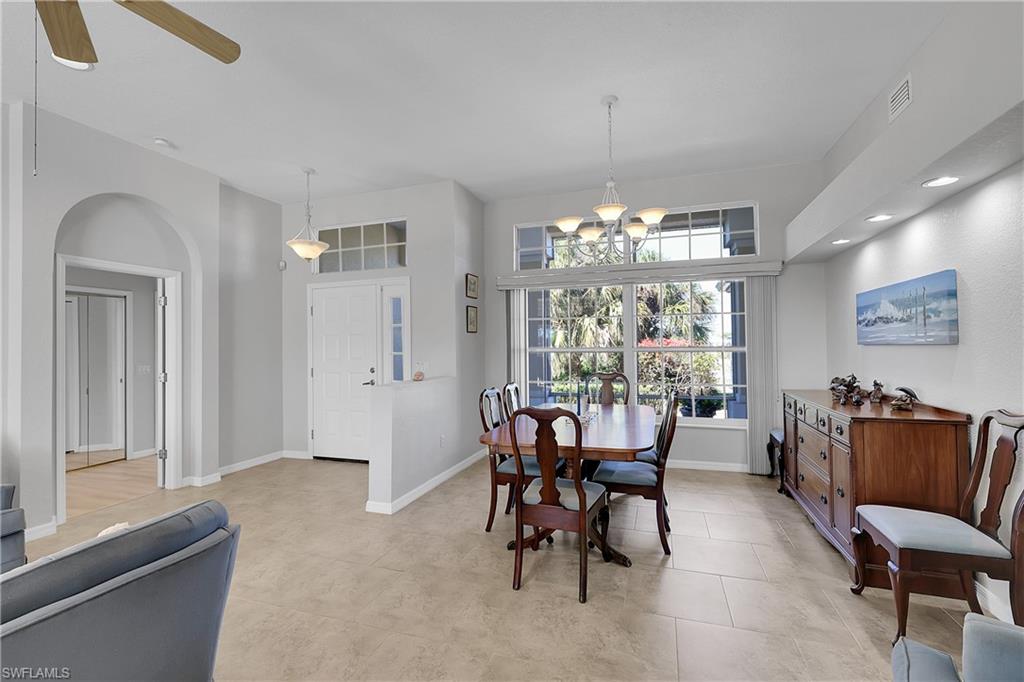 Spacious dining room with a variety of lighting and high decorative shelf, view of tropical landscaping. This home is full of light, check out the beautiful transom windows
