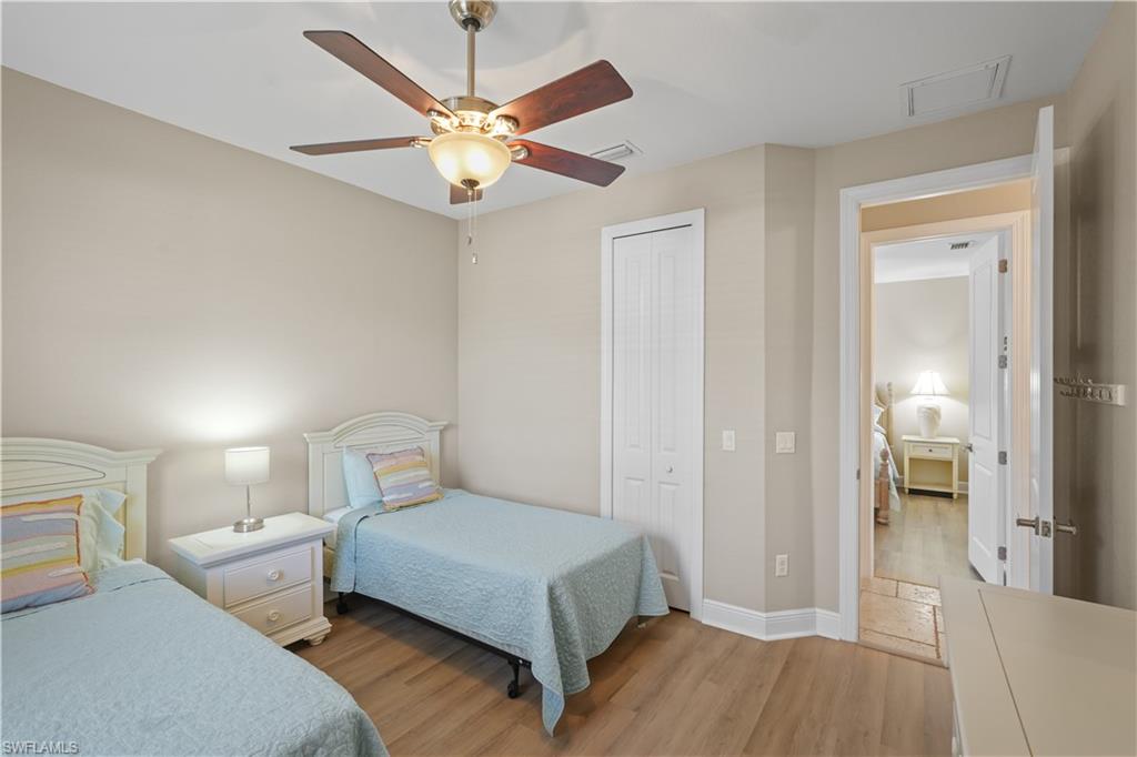 Bedroom with light wood-type flooring, a closet, and a ceiling fan