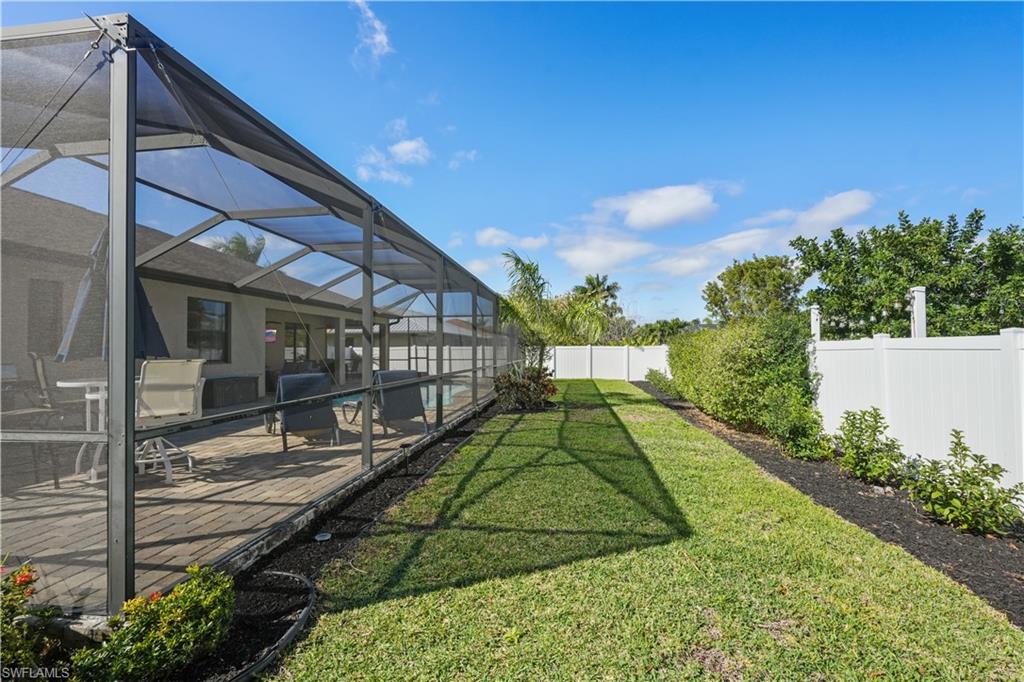 Fenced backyard featuring a lanai and a sunroom