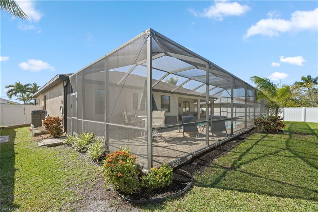 Rear view of property featuring a fenced backyard, a lanai, and a sunroom