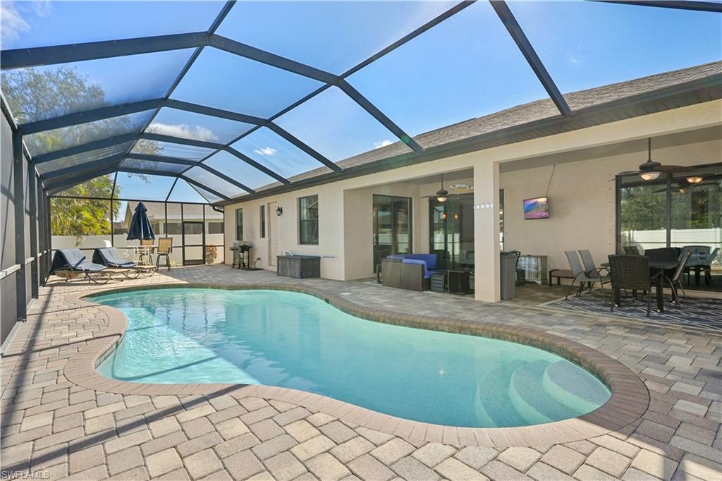 Swimming pool with a sunroom, a patio, a lanai, and outdoor dining space
