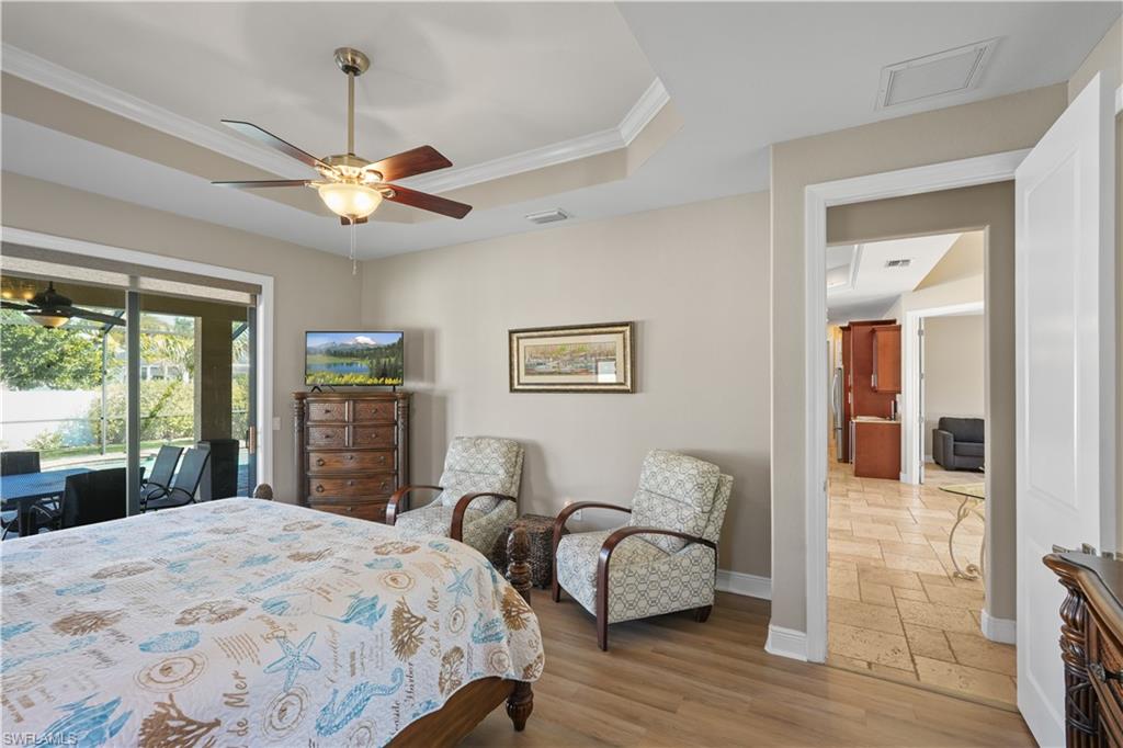 Bedroom featuring access to outside, crown molding, a ceiling fan, and wood finished floors