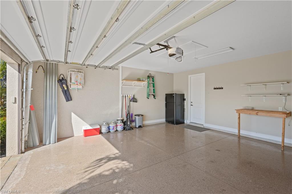 Garage with freestanding refrigerator and a garage door opener