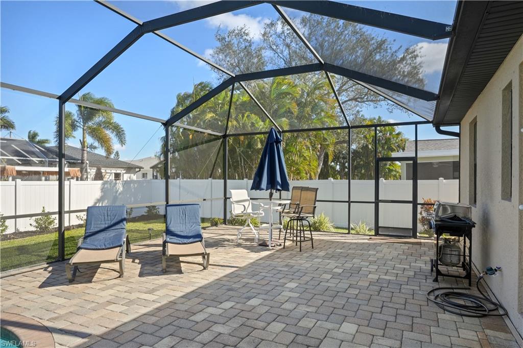 Fenced backyard with glass enclosure, a sunroom, and a patio