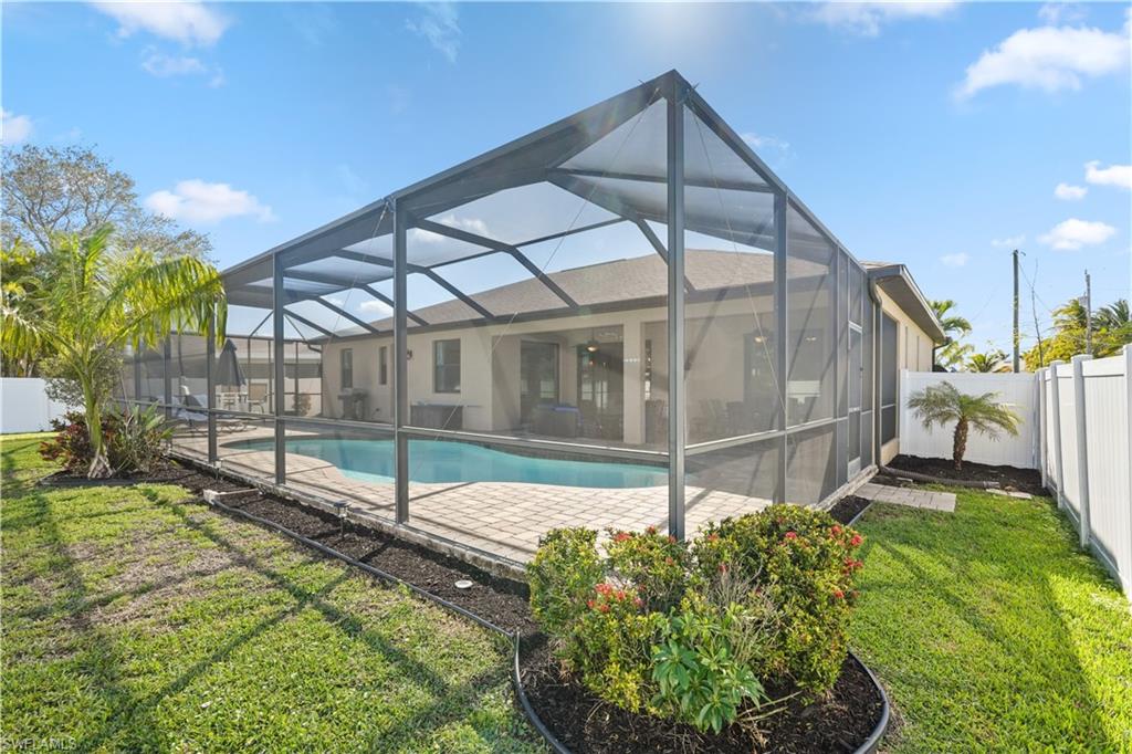 Back of house featuring a sunroom, a fenced backyard, glass enclosure, and a patio area