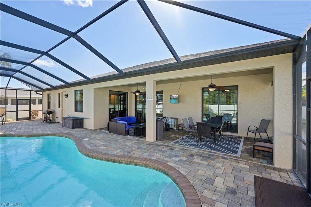 Swimming pool with a sunroom, glass enclosure, a patio, and outdoor lounge area