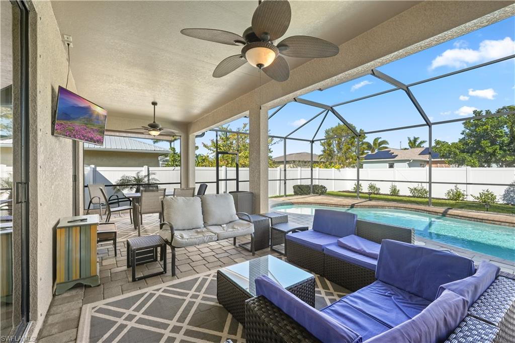 Fenced backyard featuring a patio, a sunroom, ceiling fan, glass enclosure, and outdoor lounge area