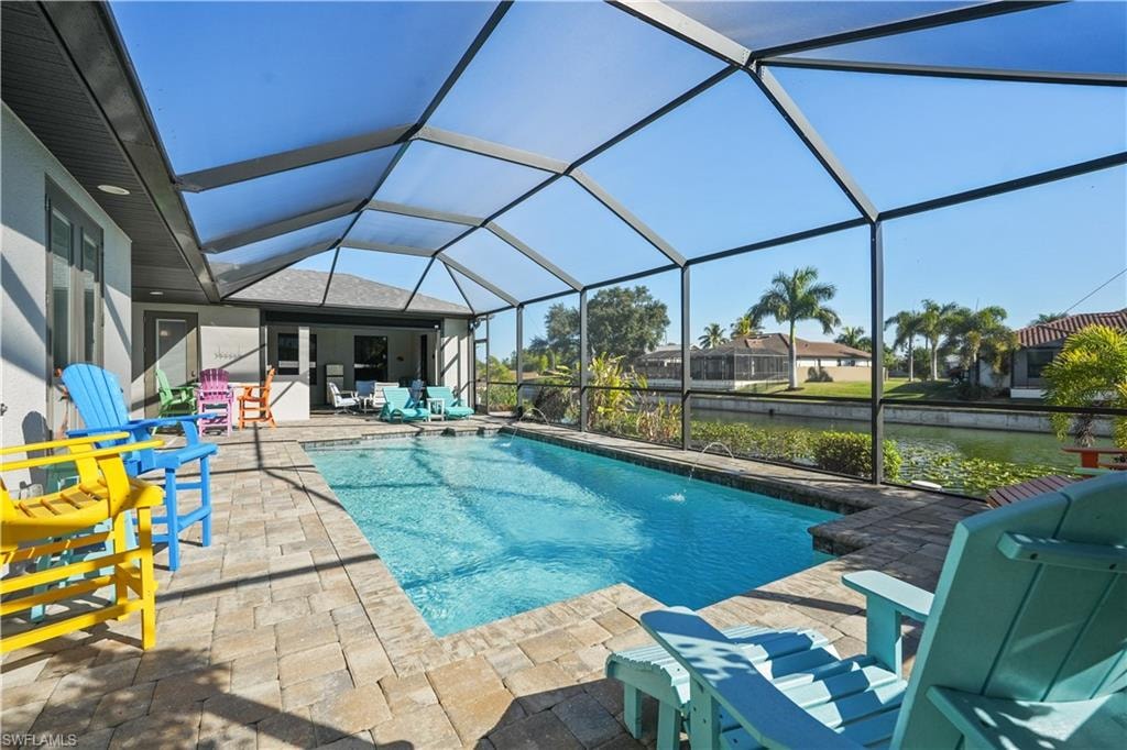 Swimming pool with a sunroom, a patio, a lanai, and a grill
