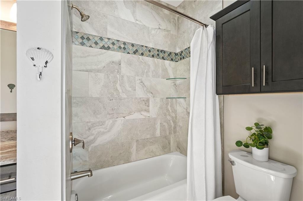 Bathroom with shower / bath combo with shower curtain and toilet