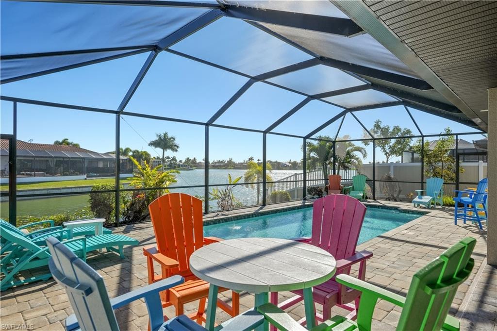 Outdoor pool with a sunroom, a patio area, a lanai, and a water view