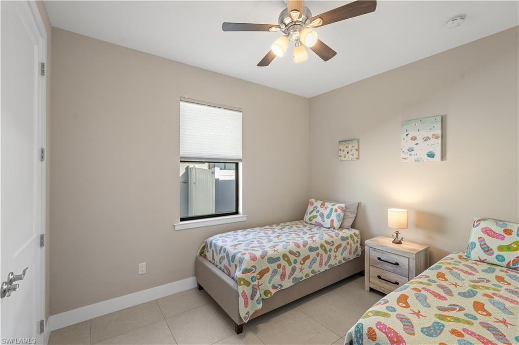 Bedroom with ceiling fan and light tile patterned floors