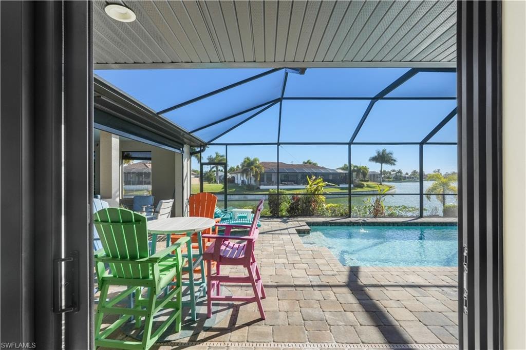 Swimming pool with a patio area, a water view, a sunroom, a lanai, and outdoor dining area