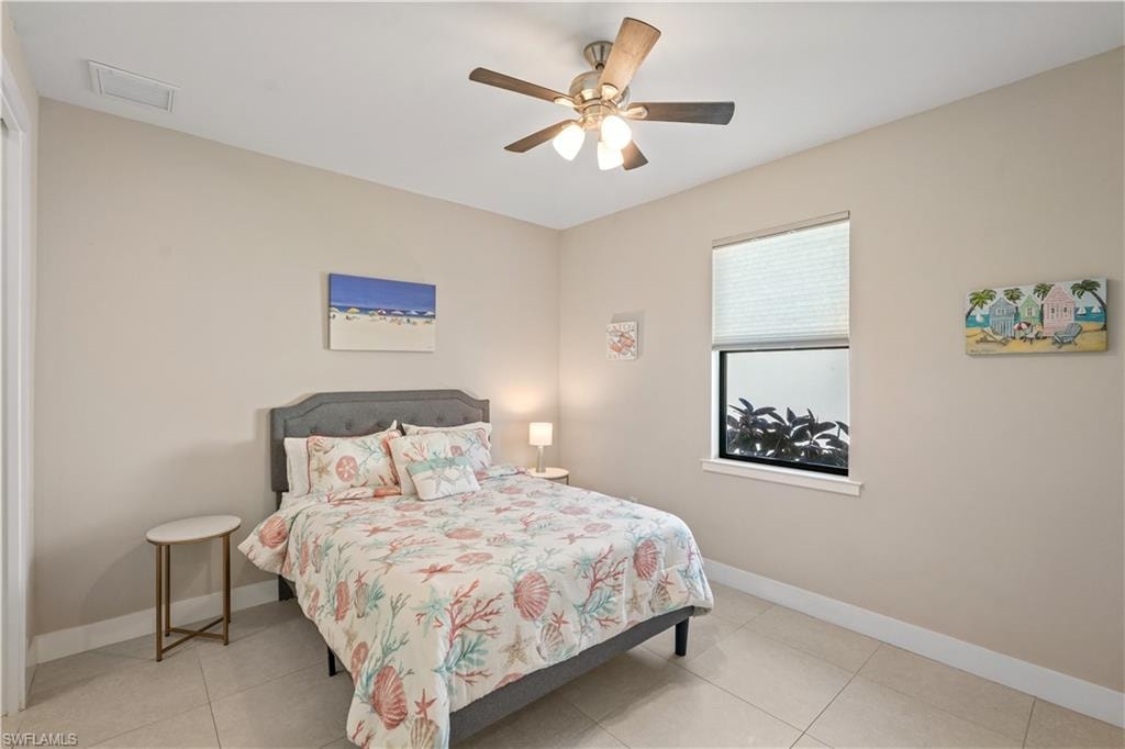 Bedroom with a ceiling fan, light tile patterned floors, and a closet