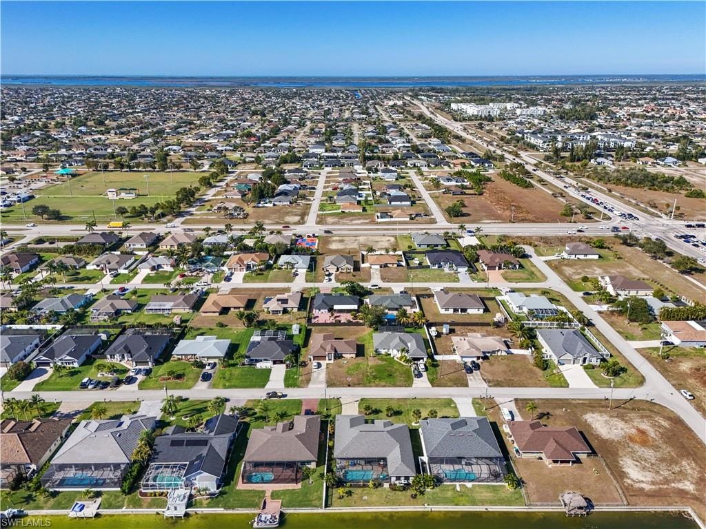 Aerial view of property and surrounding area with nearby suburban area