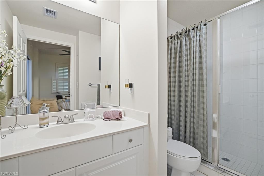 Full bathroom featuring a stall shower, vanity, and ensuite bath