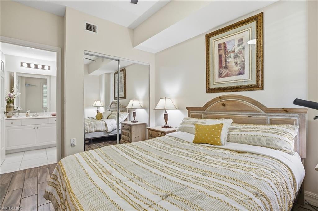 Bedroom featuring wood finish floors, a closet, ceiling fan, and ensuite bath