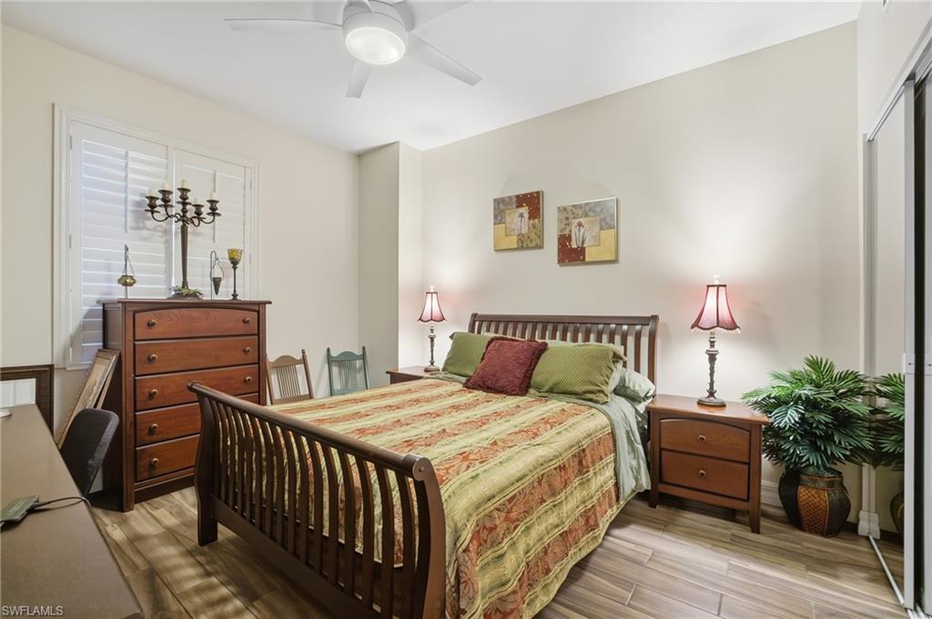 Bedroom with light wood finished floors, ceiling fan, and a closet