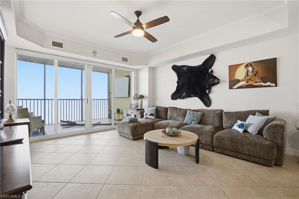 Living area featuring crown molding, ceiling fan, and light tile patterned floors