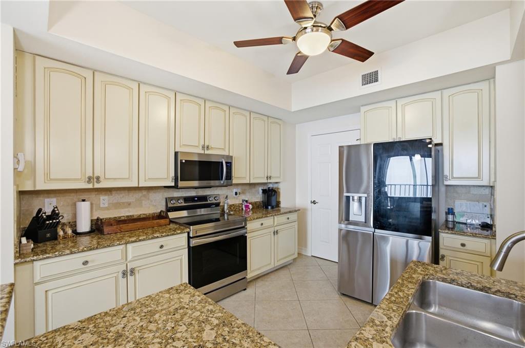 Kitchen featuring cream cabinetry, appliances with stainless steel finishes, and backsplash