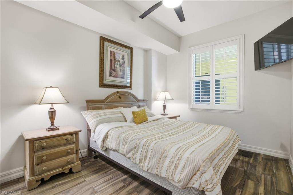 Bedroom with dark wood-style flooring and a ceiling fan