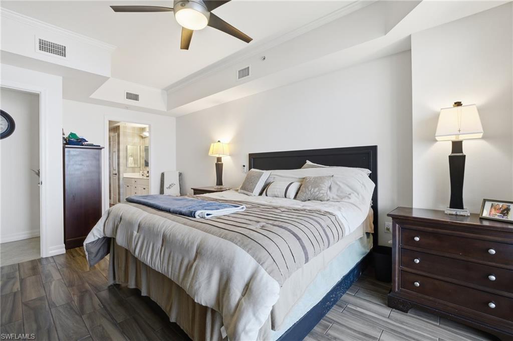 Bedroom with crown molding, wood tiled floors, ceiling fan, and ensuite bathroom