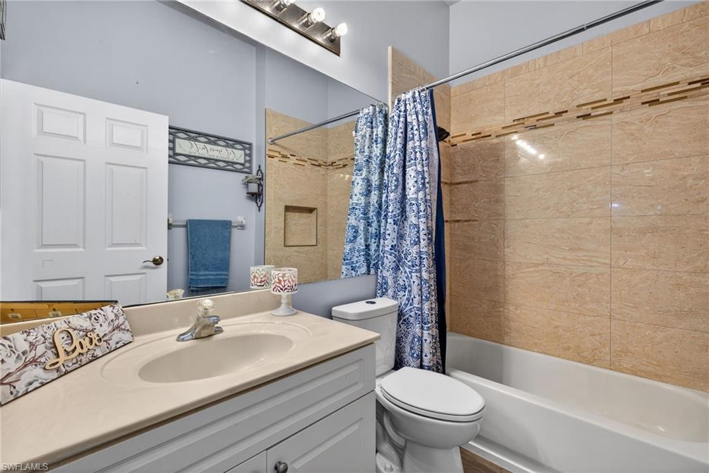 Bathroom featuring vanity and shower / bath combo with shower curtain