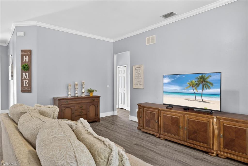 Living area with ornamental molding and wood finished floors