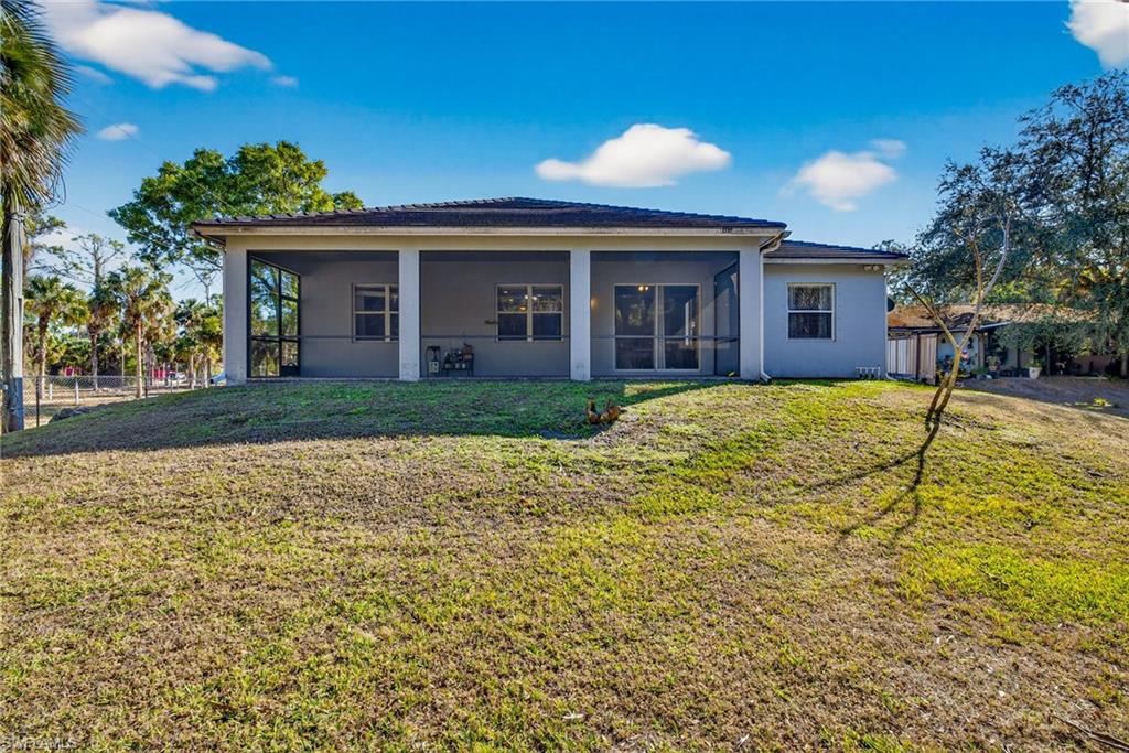 Back of property featuring stucco siding and a sunroom