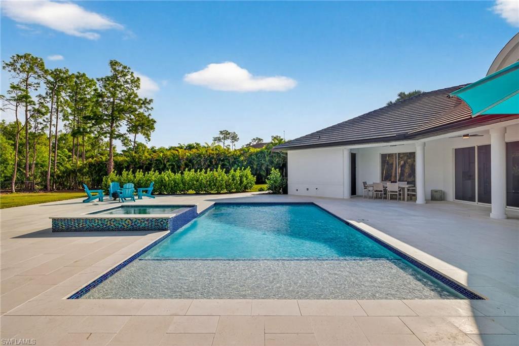 Integrated pool / hot tub with a patio area and outdoor dining area