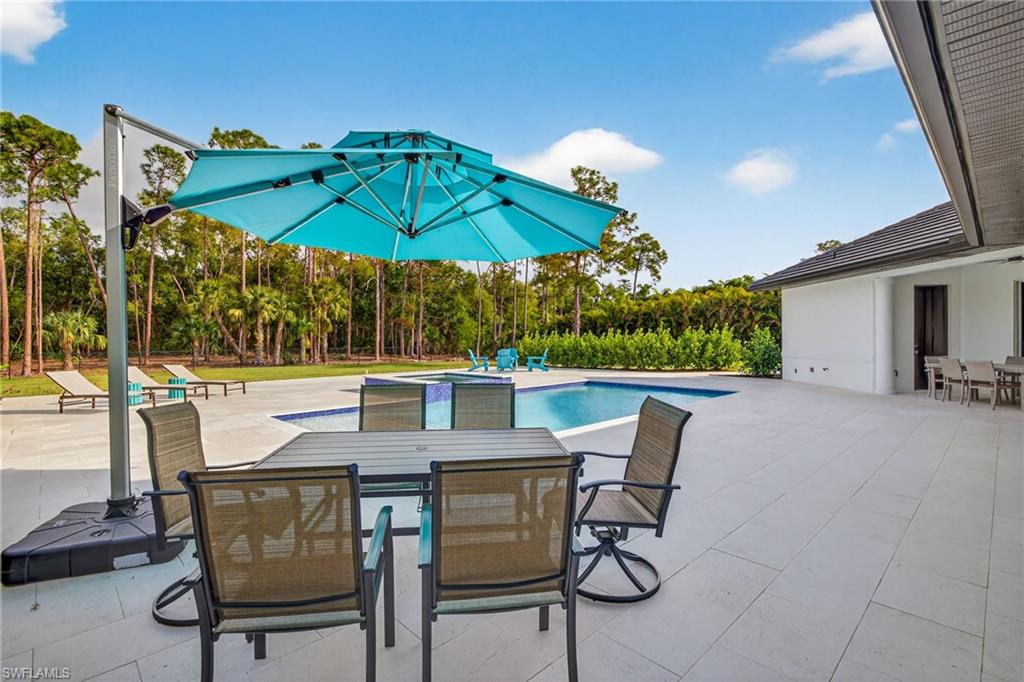 Integrated pool / spa featuring outdoor dining space and a patio