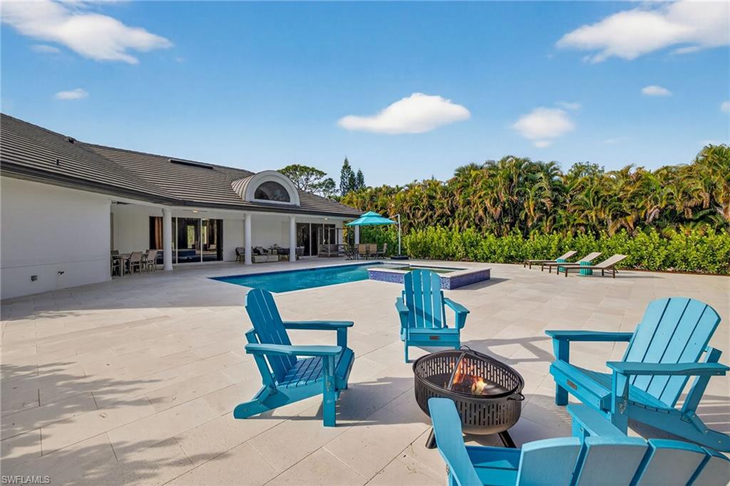Relaxing pool / spa featuring a patio and a fire pit