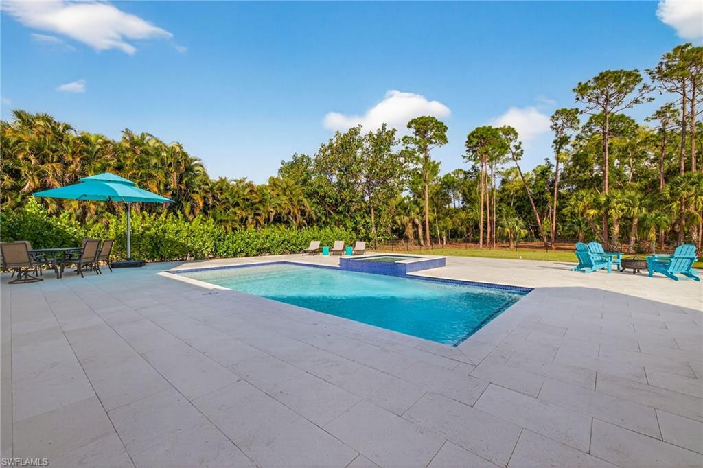 Integrated pool / hot tub with a patio and outdoor dining area