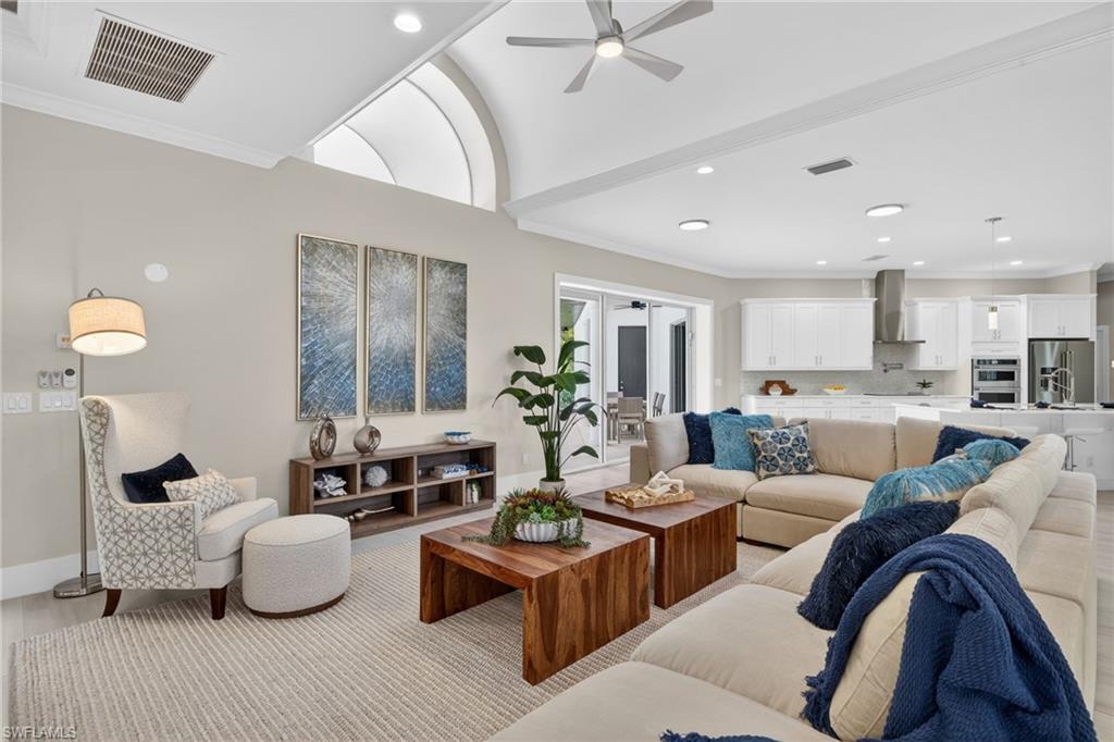 Living room with ceiling fan, ornamental molding, recessed lighting, and wood finished floors