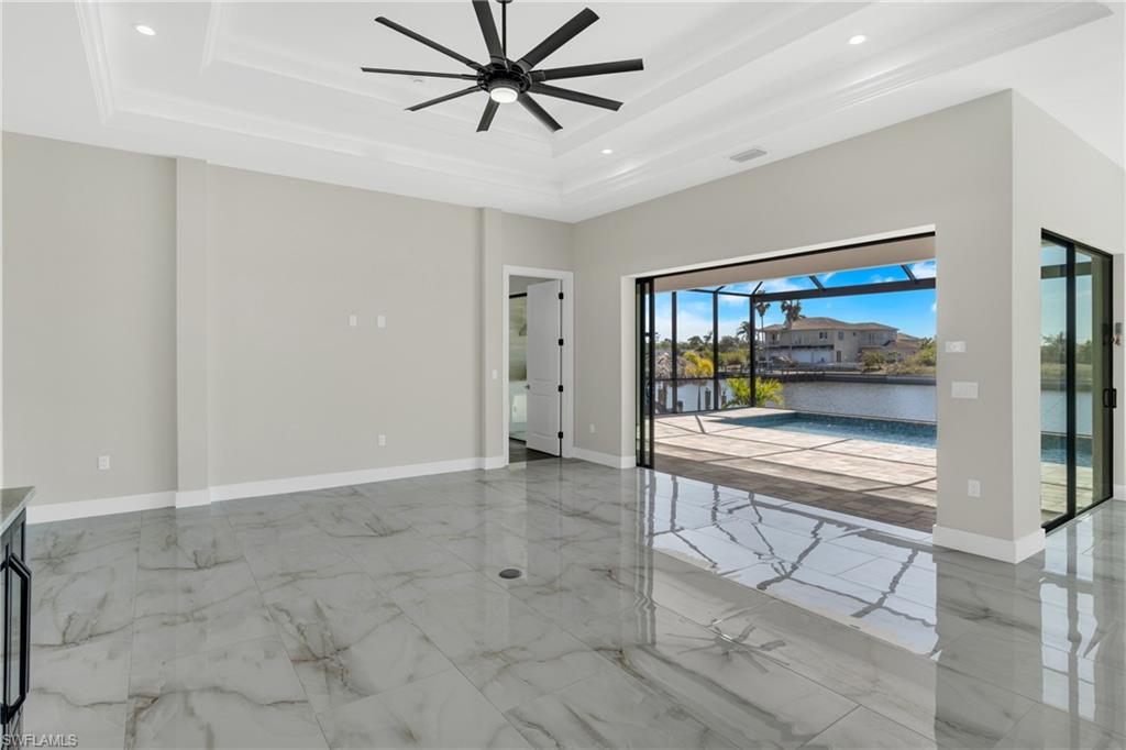 Spare room featuring a sunroom, a ceiling fan, a water view, light marble finish floors, and recessed lighting