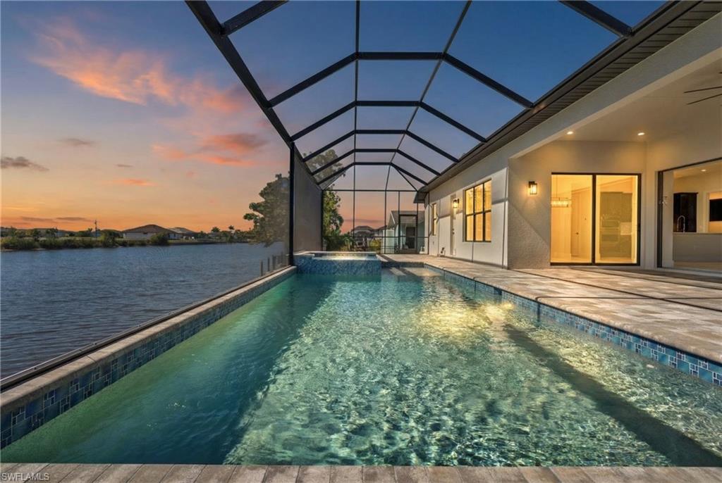 Relaxing pool / spa featuring a sunroom, a patio area, and a lanai