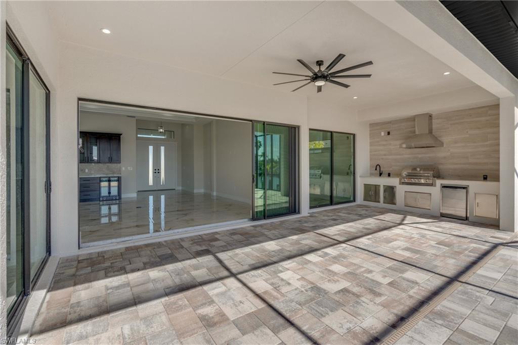 View of patio with area for grilling, ceiling fan, and french doors