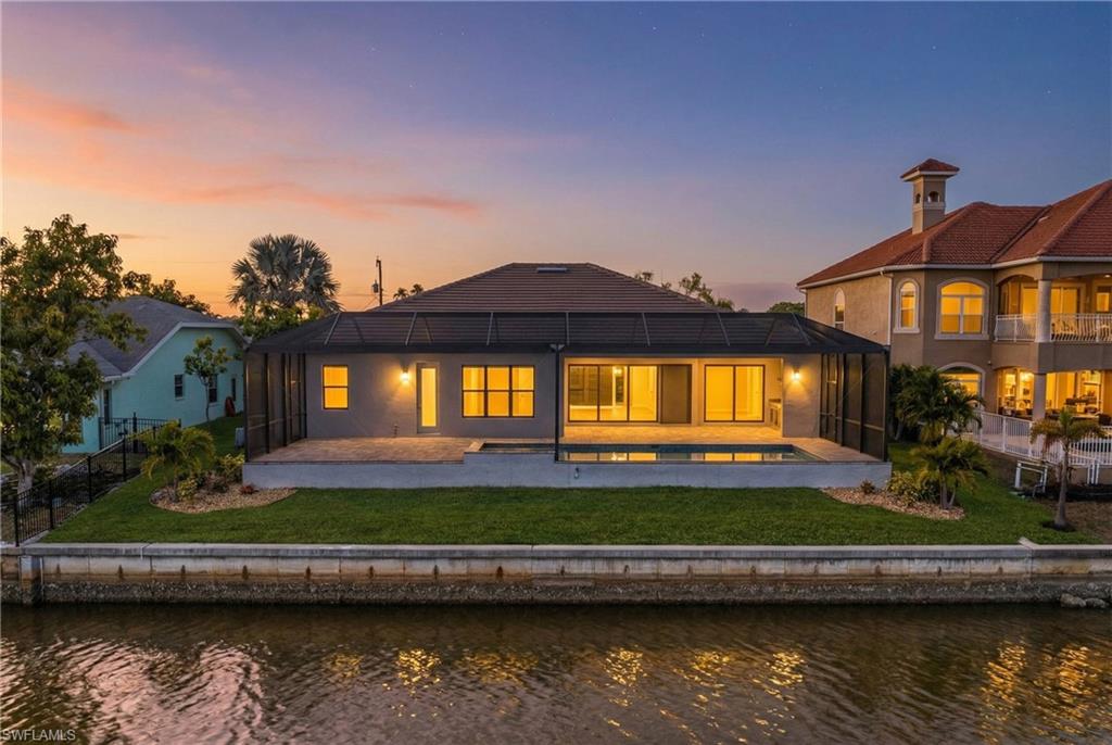 Rear view of house with a patio area, a water view, a fenced backyard, and a sunroom