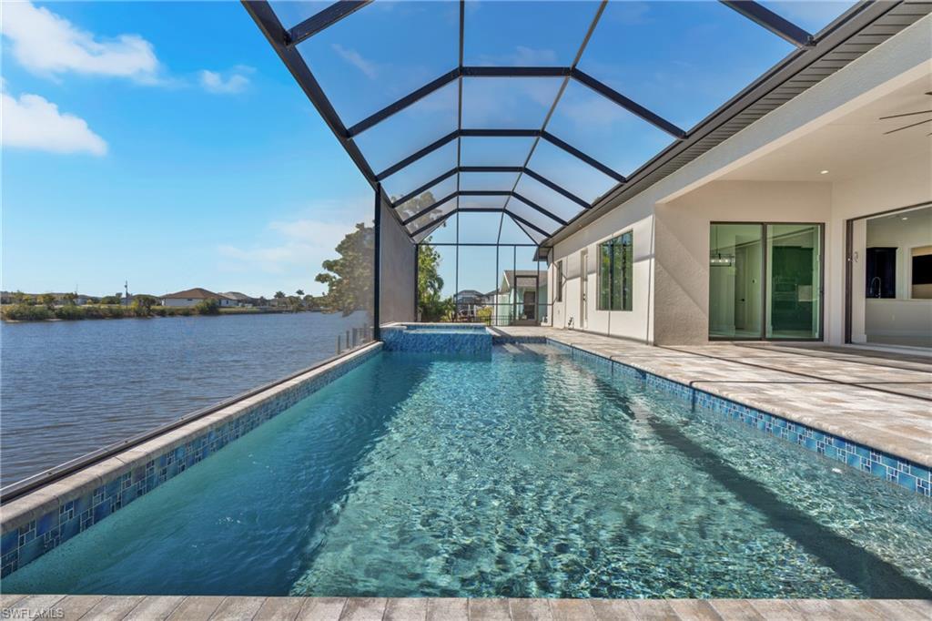 Combined pool / hot tub featuring a sunroom, glass enclosure, and a patio