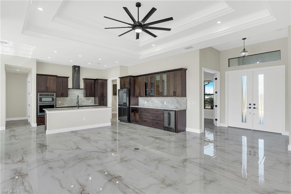 Kitchen with open floor plan, glass insert cabinets, a ceiling fan, french doors, and smart refrigerator