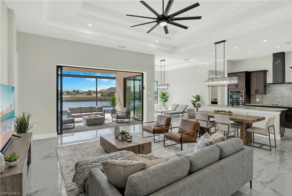 Living area with a water view, a ceiling fan, and recessed lighting