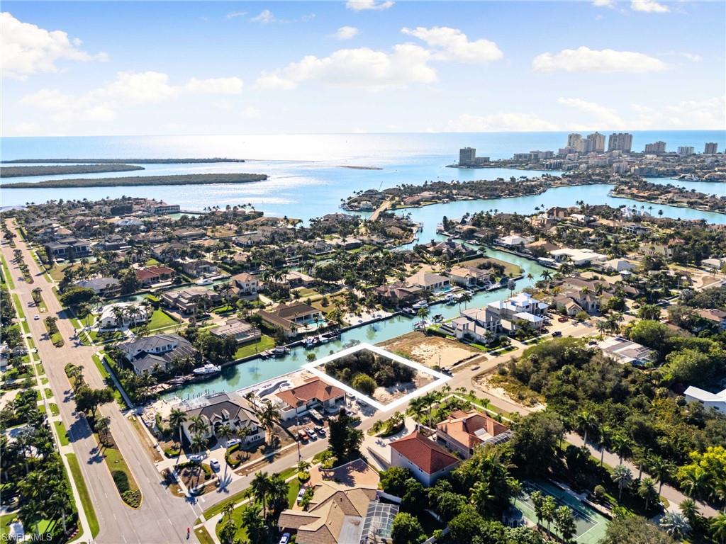 Aerial view of property and surrounding area featuring nearby suburban area and a nearby body of water