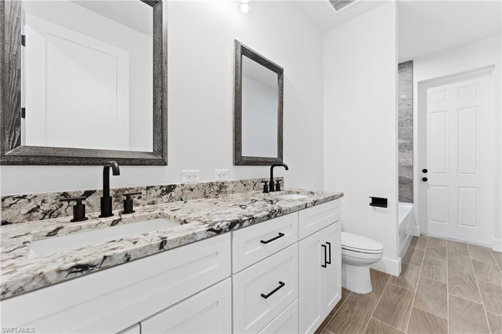 Bathroom featuring double vanity and  shower combination